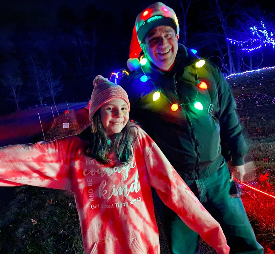 Wayne Gateman, creator of the Crazy Tech Christmas Animated Light Show in Lakeville, poses for a photo with visitor Gracianna Quintero of Raynham.