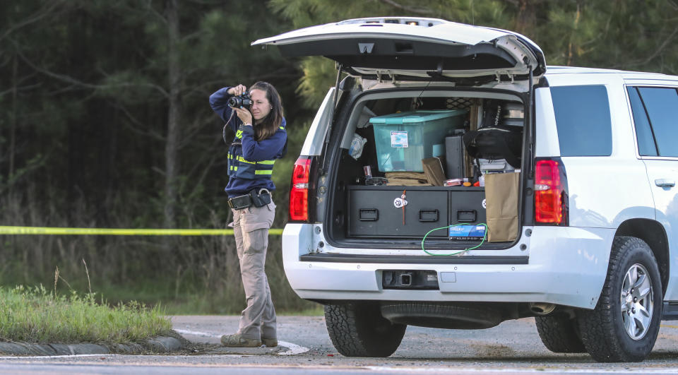 A Georgia Bureau of Investigation agent processes the crime scene after three metro Atlanta officers were injured Monday, April 12, 2021, after a police chase entered Carroll County, Ga., and a passenger fired multiple rounds with a rifle, officials said. Georgia authorities said one suspect was killed and the other arrested following the chase. (John Spink/Atlanta Journal-Constitution via AP)