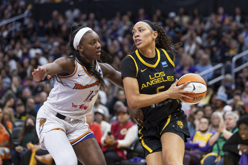 FILE - Los Angeles Sparks forward Dearica Hamby (5) drives to the basket while being guarded by Phoenix Mercury forward Michaela Onyenwere (12) during a WNBA basketball game May 19, 2023, in Los Angeles. Recent allegations by Hamby that her coach harassed her for being pregnant have shined a renewed spotlight on one of the biggest challenges that female professional athletes face. The athletes say that pregnant athletes continue to encounter attitudes ranging from ambivalent to outright hostile from leagues, coaches — and even fellow players. (AP Photo/Jeff Lewis, File)