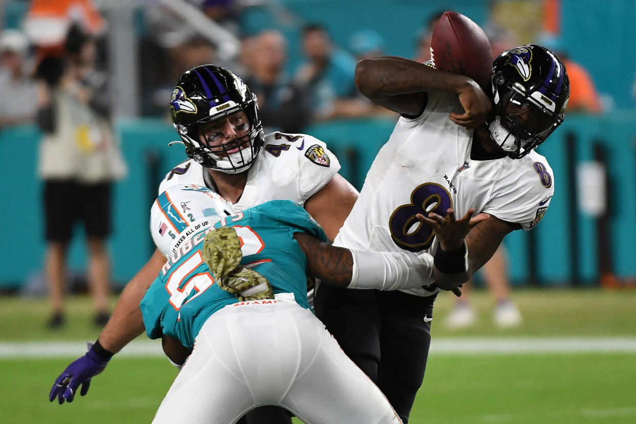 Lamar Jackson of the Baltimore Ravens is sacked by Elandon Roberts of the Miami Dolphins. (Photo by Eric Espada/Getty Images)