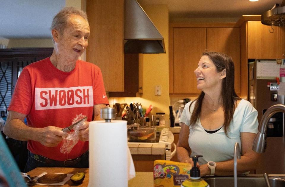 Isabel Toca, a breast cancer survivor, right, prepares for tea while her husband, Mario, makes a snack in their home on Wednesday, Oct. 4, 2023, in Miami, Fla. “Most people couldn’t work with their partners but it works because we’re both strong personalities,” said Toca. “I think I’m pretty easy,” Mario said. Alie Skowronski/askowronski@miamiherald.com