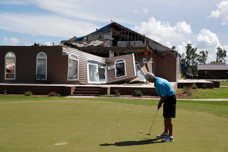 A golfer practices on the putting green in front of what remains of the Clubhouse at the Black Creek Golf Club in Ellabell. The clubhouse was destroyed in April when a tornado ripped through the area.