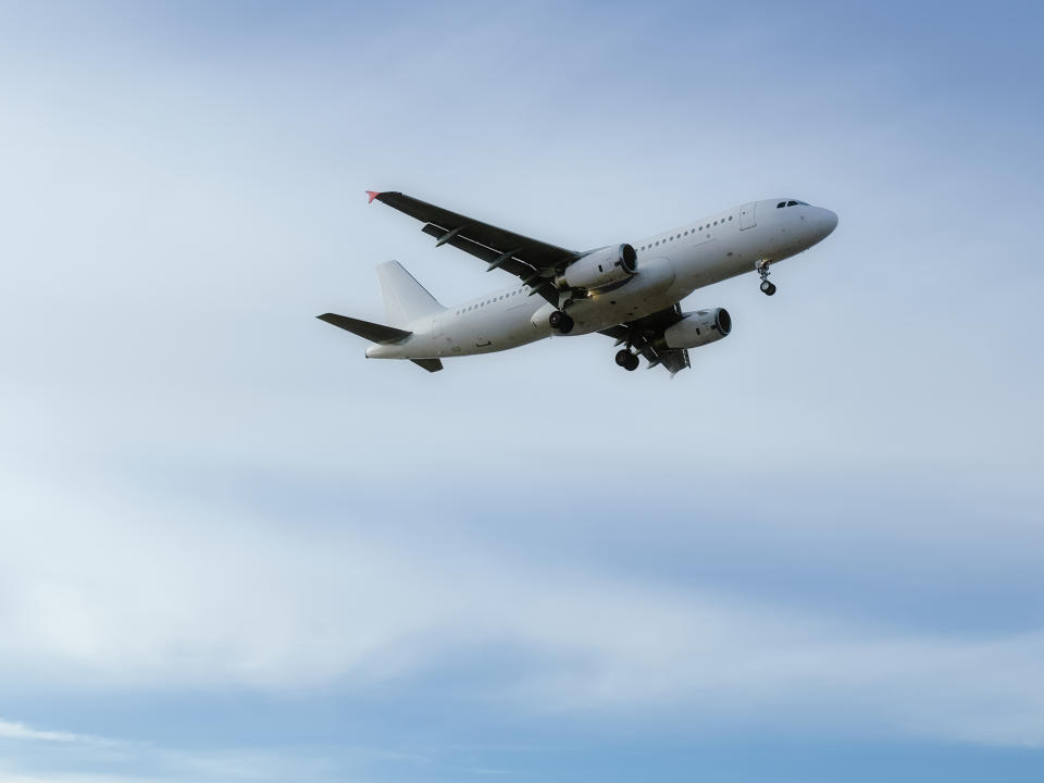 An airplane in flight against a cloudy sky