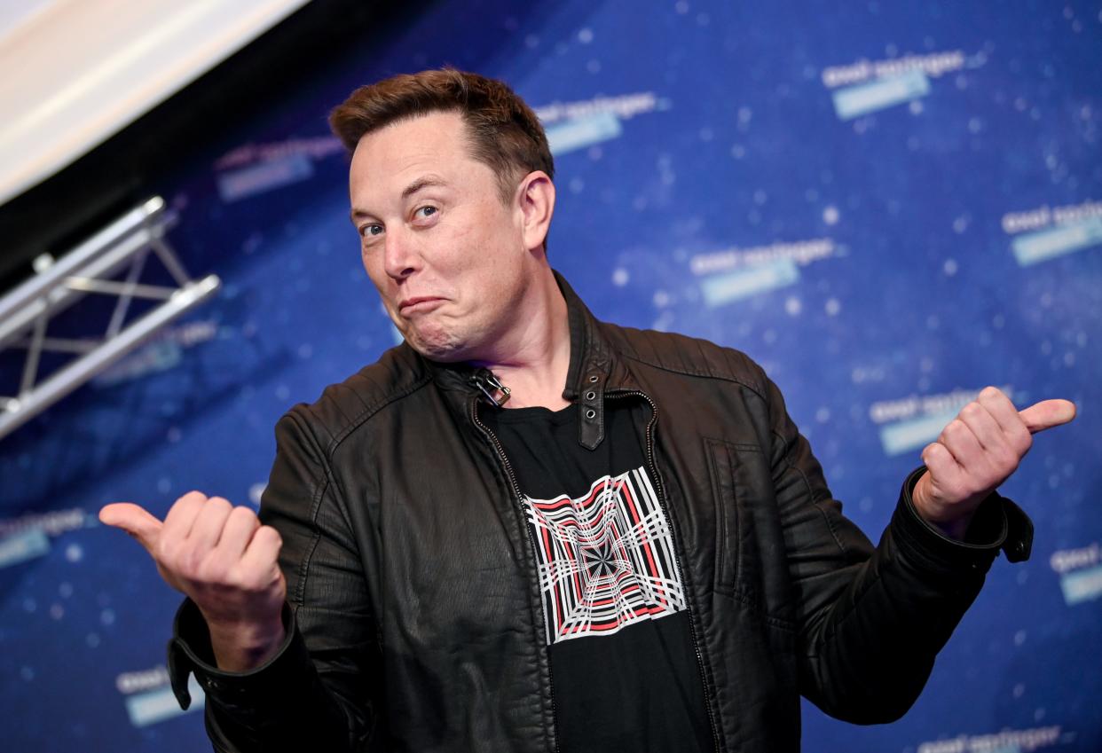 Elon Musk posing for a photo in a questioning manner in front of a space-themed background.