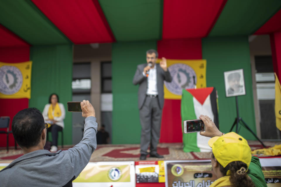 Protesters film a man speaking during a march organized by a national trade union to commemorate Labor Day, in Rabat, Morocco, Monday, May 1, 2023. (AP Photo/Mosa'ab Elshamy)