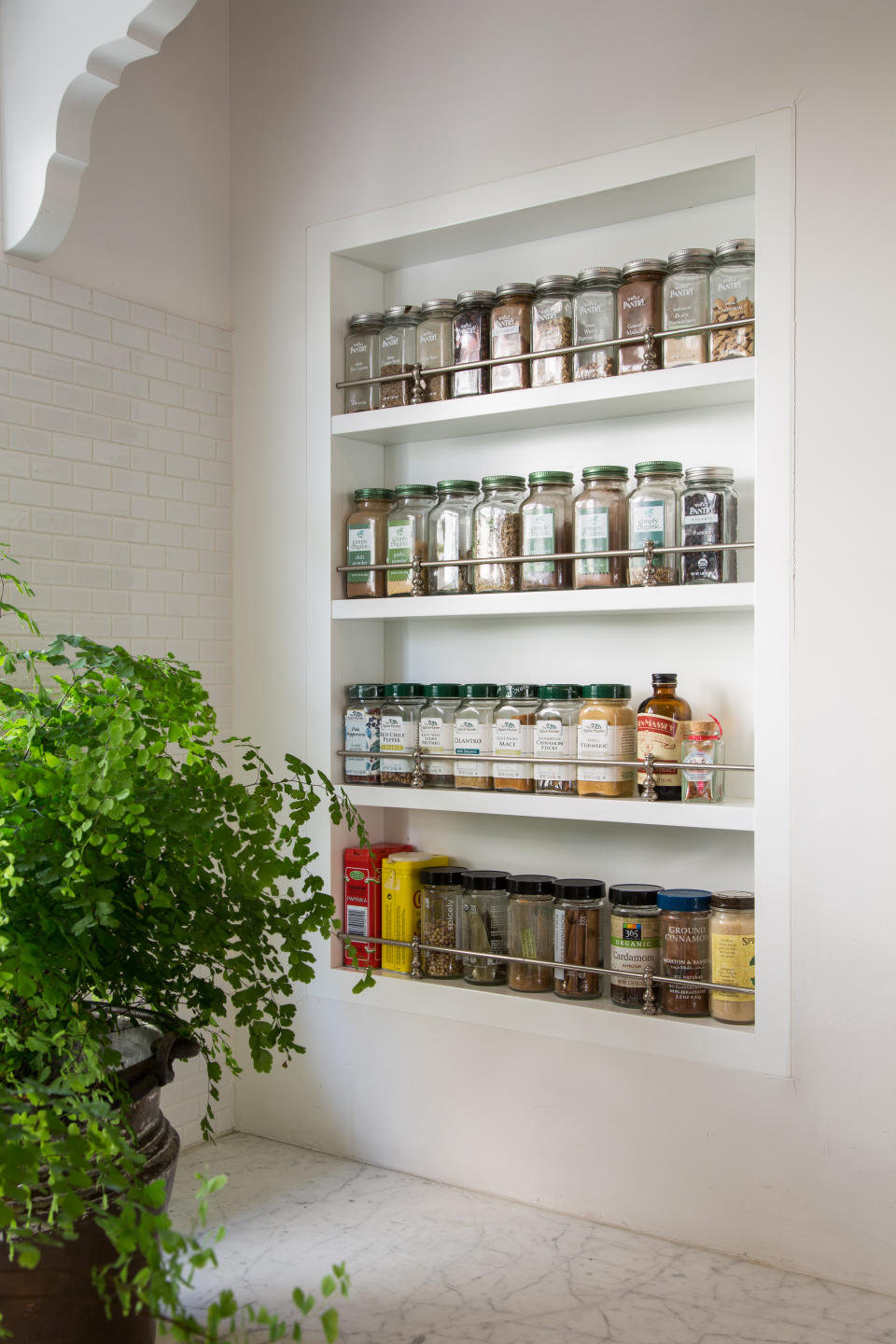 spice rack within a small alcove in kitchen wall