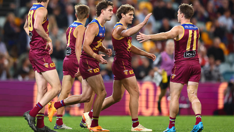 Brisbane Lions players celebrate a goal.