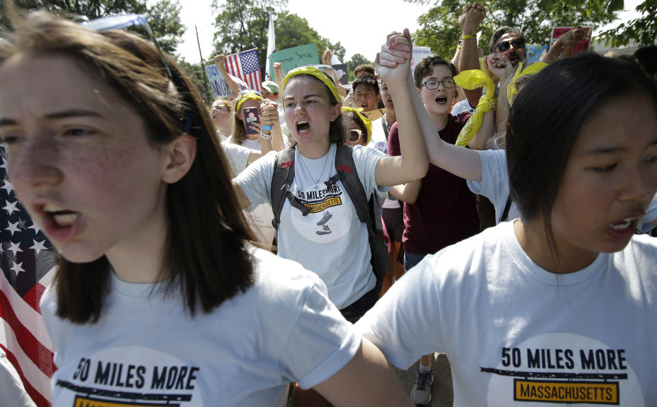 Newton, Mass., high school student Madeline Ranalli, 17, center, clasps hands and chants slogans during the final mile of a 50-mile march, Sunday, Aug. 26, 2018, in Springfield, Mass. The march, held to call for gun law reforms, began Thursday, Aug. 23, in Worcester, Mass., and ended Sunday, in Springfield. The march ended with a rally near the headquarters of gun manufacturer Smith & Wesson. (AP Photo/Steven Senne)