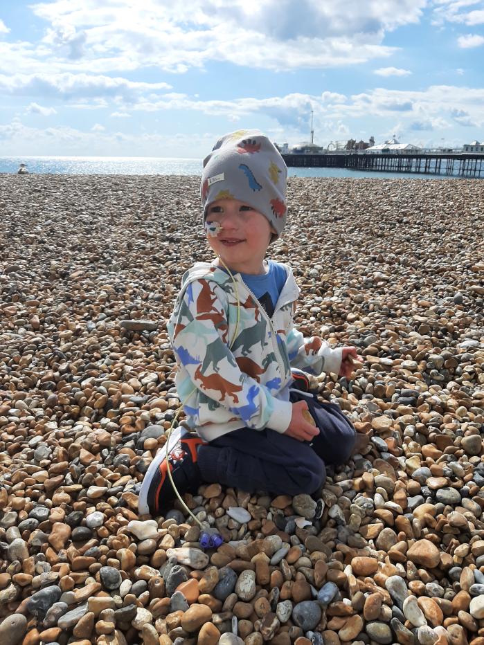 Boy sitting down, with a hat on his head