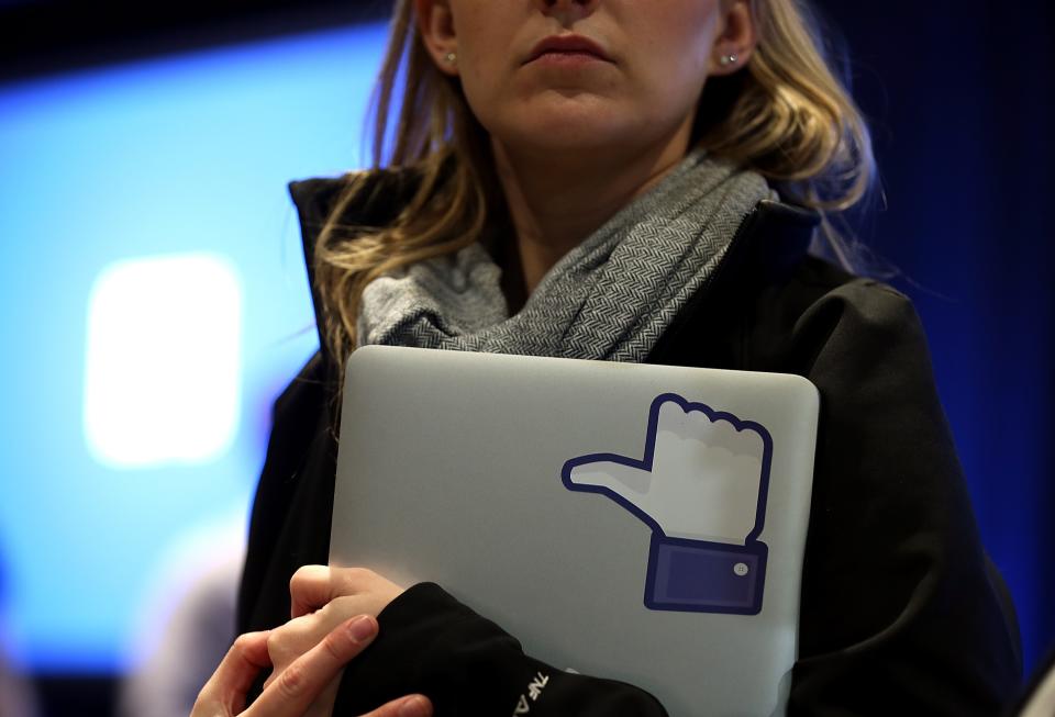 A Facebook employee holds a laptop with a “like” sticker on it during an event at Facebook headquarters during an event at Facebook headquarters on April 4, 2013 in Menlo Park, California. (Photo by Justin Sullivan/Getty Images)