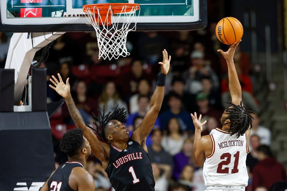 Boston College forward Devin McGlockton (21) shoots while guarded by Louisville forward Mike James (1) during the first half of an NCAA college basketball game Wednesday, Jan. 25, 2023, in Boston. (AP Photo/Greg M. Cooper)