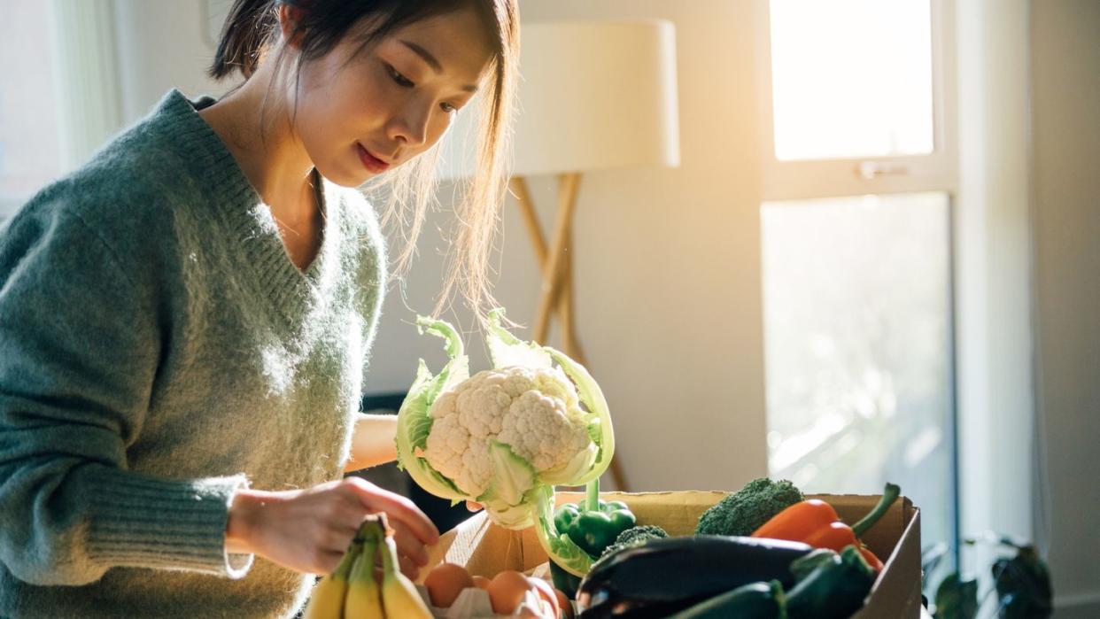 young woman receiving fresh food home delivery