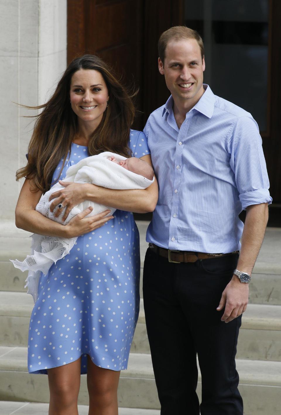 FILE - In this July 23, 2013 photo, Britain's Prince William and Kate, Duchess of Cambridge pose with the Prince of Cambridge outside St. Mary's Hospital in London where the Duchess gave birth on Monday, July 22. Princess Diana wore a caftan-like outfit that hid the post-childbirth tummy bump when William was born. In contrast, the former Kate Middleton, in her first public appearance after giving birth, wore a dress that did not camouflage her belly, and many women are applauding her choice. (AP Photo/Kirsty Wigglesworth)