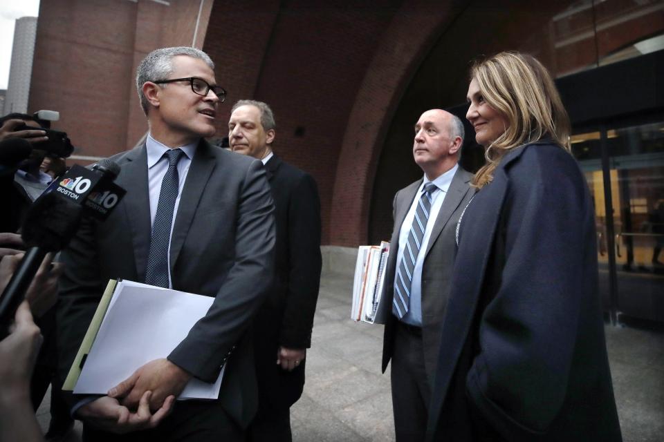 Attorney John Littrell, left, speaks to the media as client Michelle Janavs, right, stands beside attorney Thomas Bienert, second from right, outside federal court, Tuesday, Feb. 25, 2020, in Boston. Janavs was sentenced to five months in prison for trying to cheat and bribe her daughters' way into college as part of a nationwide college cheating scam. (AP Photo/Elise Amendola)