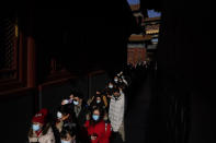 People wearing face masks to help curb the spread of the coronavirus visit Yonghegong Lama Temple as they offer prayers on the first day of the New Year in Beijing, Friday, Jan. 1, 2021. President Xi Jinping said in a New Year address that China has made major progress in developing its economy and eradicating rural poverty over the past year despite the coronavirus pandemic. (AP Photo/Andy Wong)