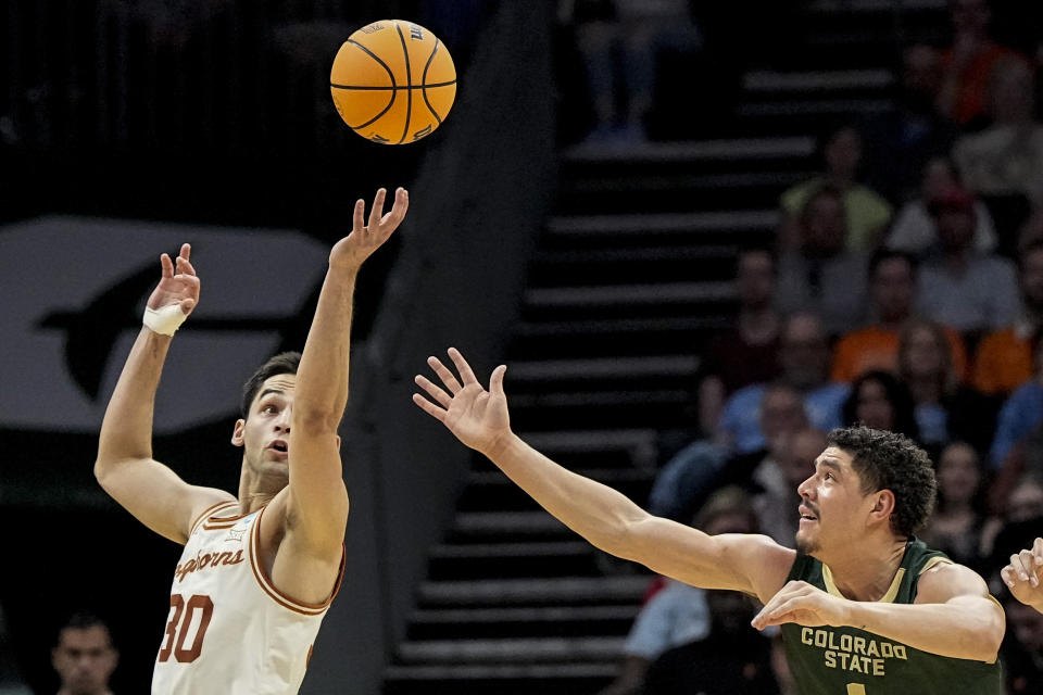 Texas forward Brock Cunningham (30) vies for a loose ball with Colorado State forward Joel Scott (1) during the first half of a first-round college basketball game in that NCAA Tournament, Thursday, March 21, 2024, in Charlotte, N.C. (AP Photo/Mike Stewart)