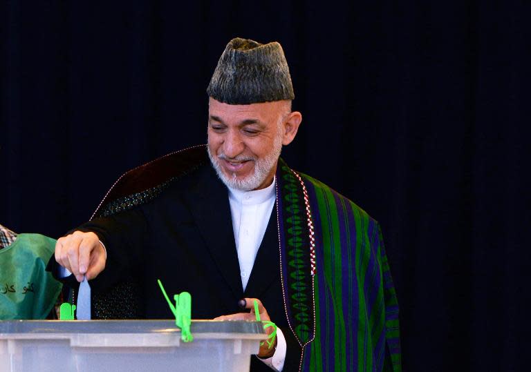 Afghan President Hamid Karzai casts his vote at a polling station in Kabul, on June 14, 2014