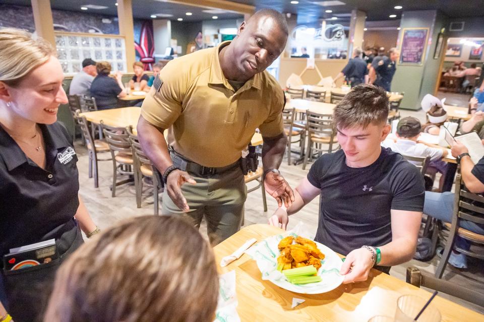 SRO Officer Derrick Miles serves customers Wednesday as Lafayette Police Officers wait tables at Deano's Pizza, with tips going to Boys and Girls Clubs of Acadiana.