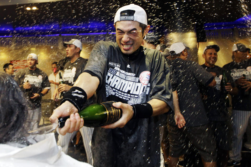 FILE - New York Yankees' Ichiro Suzuki douses the team photographer as teammates celebrate in the clubhouse after their 14-2 win over the Boston Red Sox in a baseball game that clinched the American League East title at Yankee Stadium in New York, Wednesday, Oct. 3, 2012. About a dozen Japanese players will play in MLB this season, adding to a list has reached about 70 since Masanori Murakami in 1964-65. (AP Photo/Kathy Willens, File)