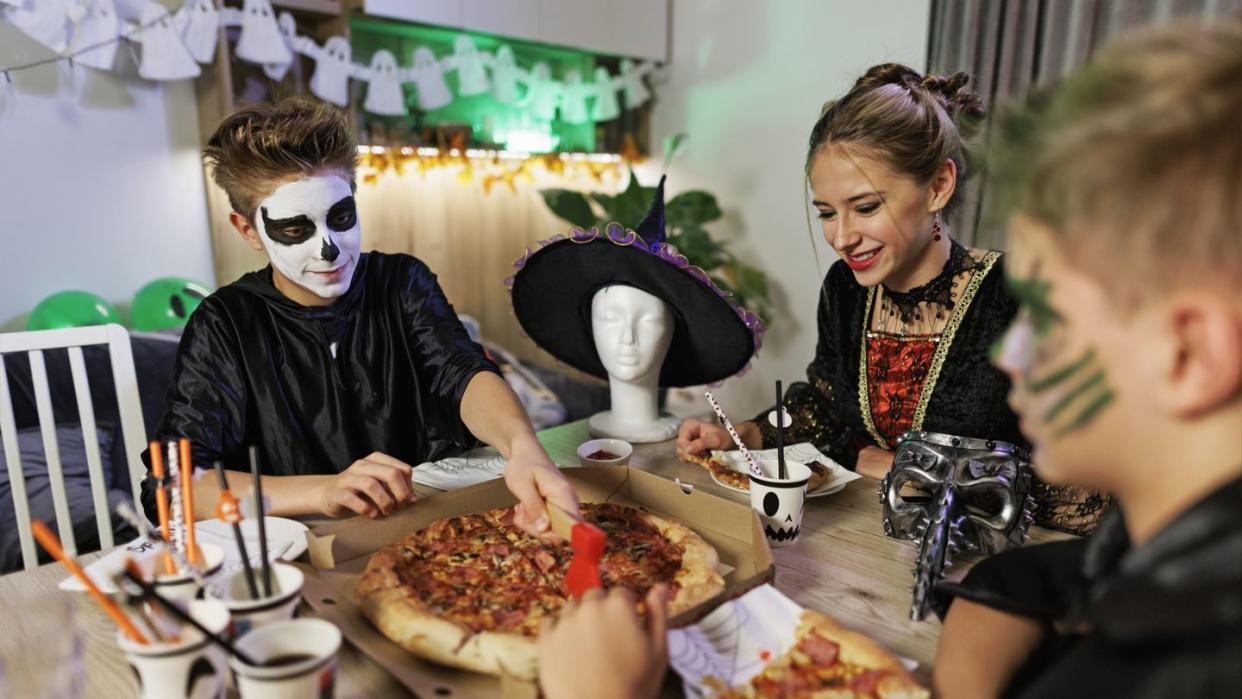 family enjoying halloween party they are eating pizza shot with canon r5