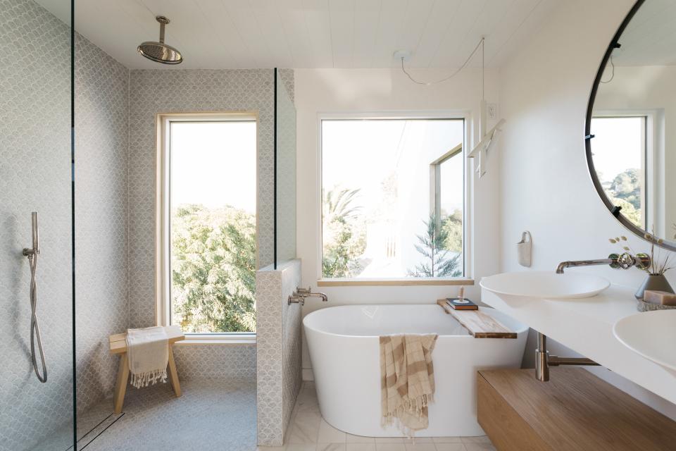 AFTER: “The natural and muted colors were also selected to accentuate the home’s beautiful views,” says Shanty of the bathroom. “We incorporated big windows and sliding doors to make the beautiful views and landscaping the main focal point in this house.”