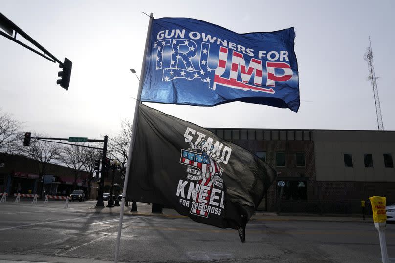 Flags fly outside a former President Donald Trump commit to caucus rally in Waterloo, Iowa