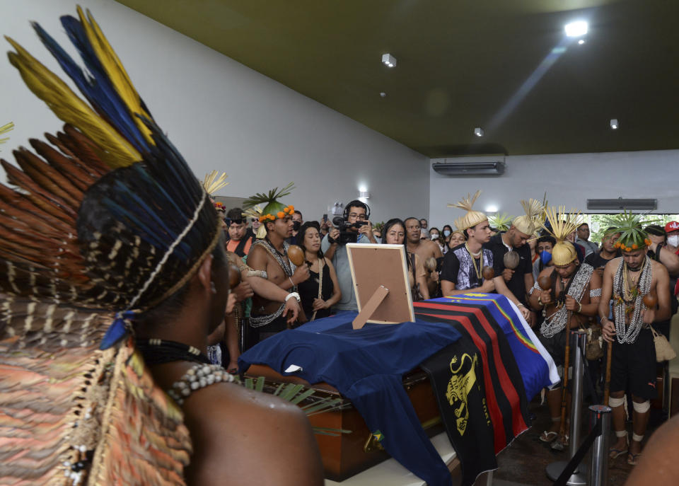 Indigenous groups, family and friends surround the coffin that contains the remains of Indigenous expert Bruno Pereira during his funeral service at the Morada da Paz cemetery, in Recife, Pernambuco state, Friday, June 24, 2022. Pereira was killed in the Amazon region with the British journalist Dom Phillips. (AP Photo/Teresa Maia)