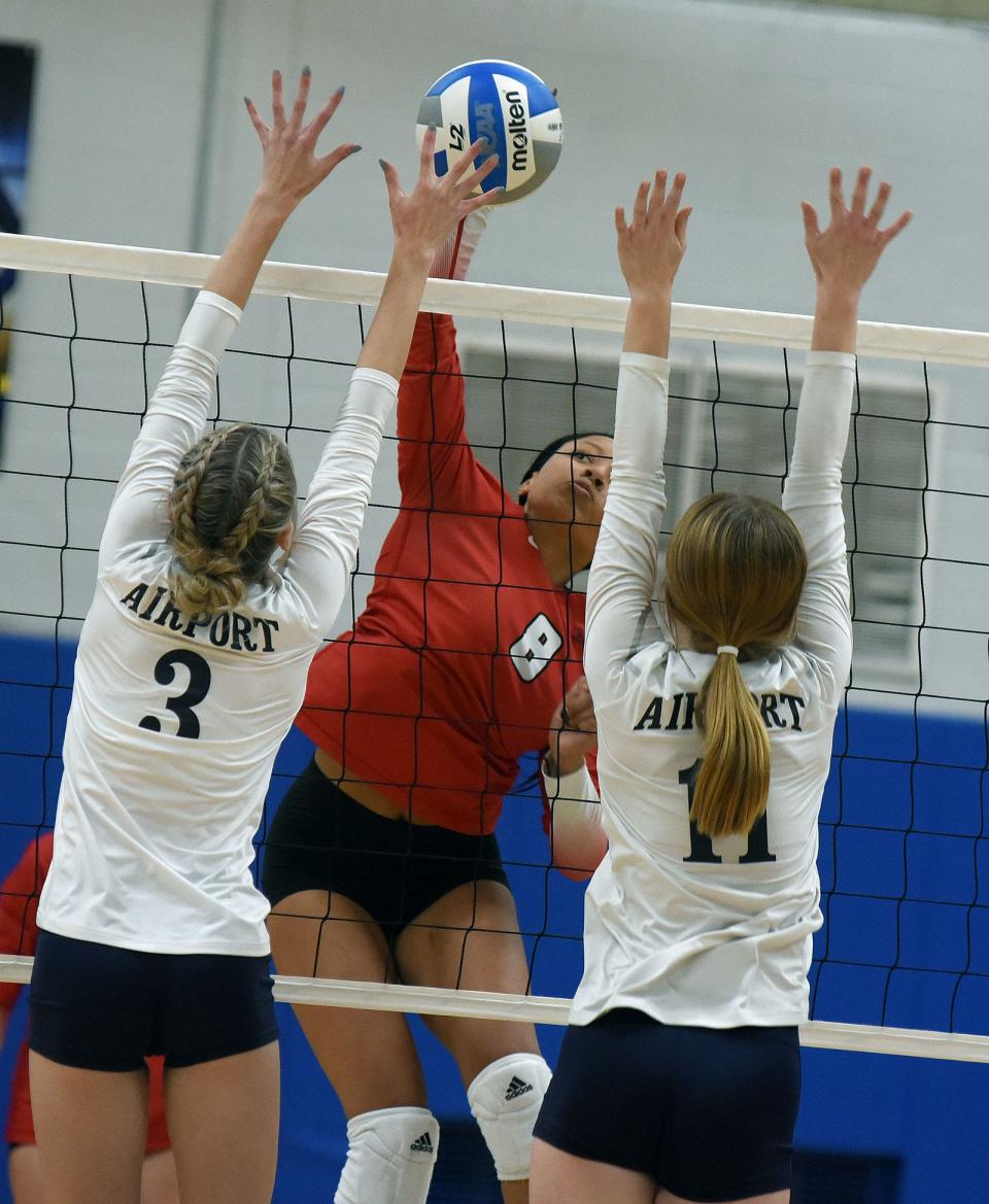Malea Wourman of Milan goes up to spike as blockers Savannah Barkley and Renee Shrewsbury of Airport attempt to block in the Division 2 District semifinals Thursday.