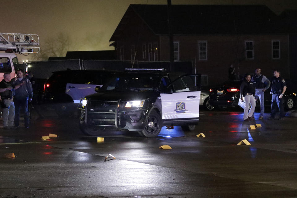 Evidence markers are placed in the Dollar General parking lot, located in the 1100 block of Opelika Road in Auburn, Ala., on Friday, Feb. 15. The scene is where an Auburn police officer was reportedly shot after stopping a suspect vehicle of an attempted robbery case. (Emily Enfinger/Opelika-Auburn News via AP)