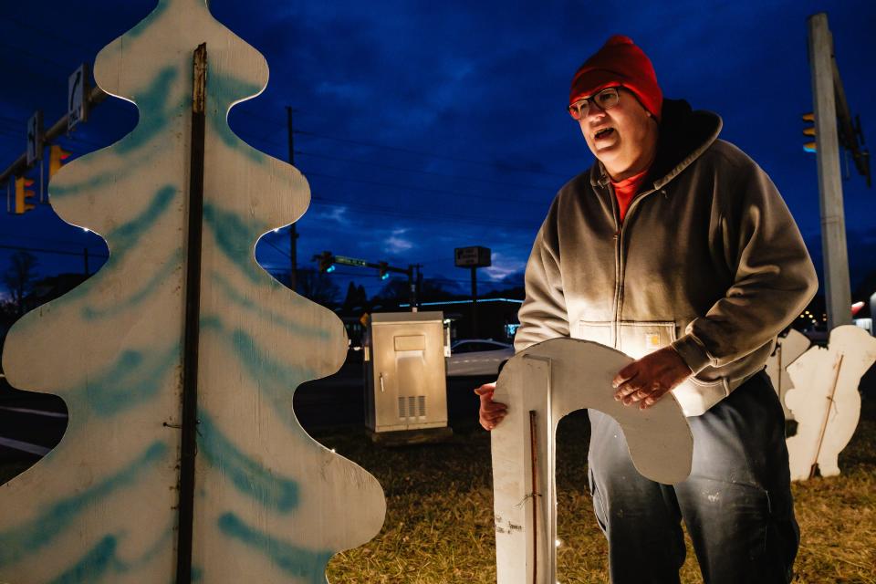 Ted Polka works to secure an illuminated candy cane at the southside Christmas display. Polka said he probably has put 35 to 40 hours of work into the display.