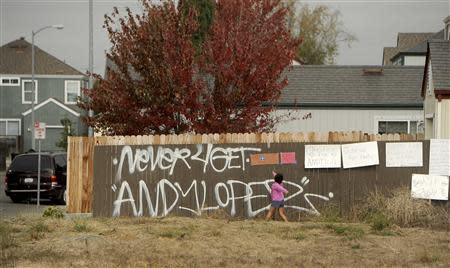 A girl reads signs in a vacant lot where 13-year-old Andy Lopez Cruz was shot and killed by sheriff's deputies on Tuesday in Santa Rosa, California October 27, 2013. REUTERS/Noah Berger