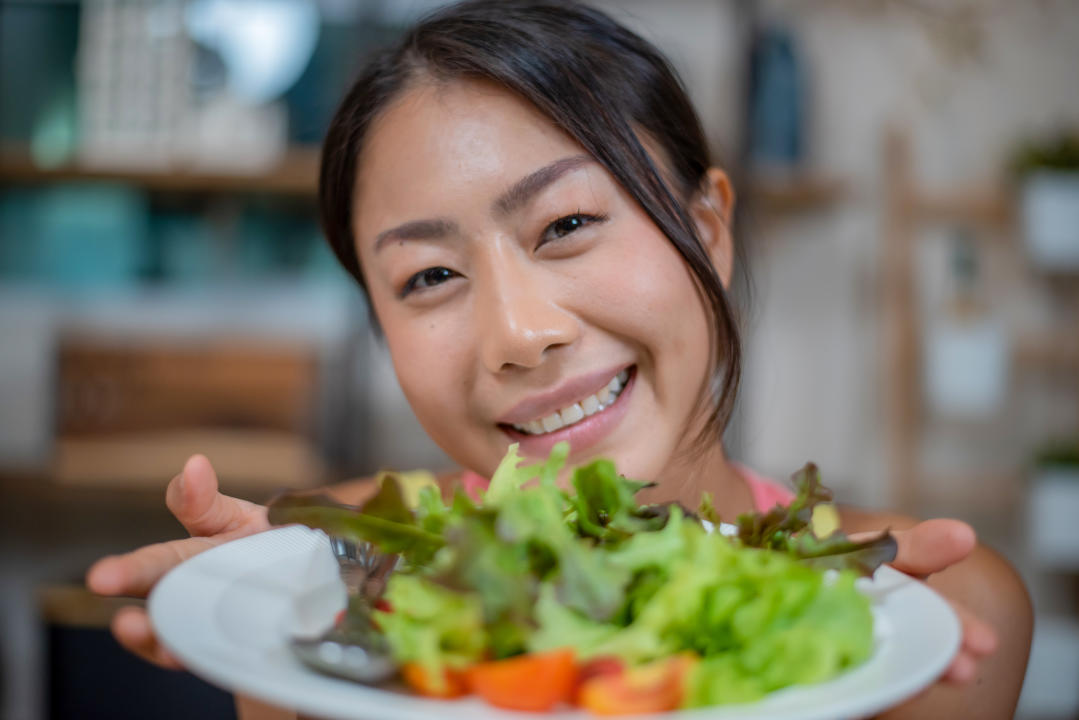 Beautiful fit woman eating healthy salad after fitness workout