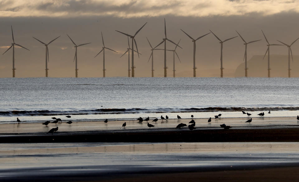 An offshore wind farm is visible from the beach in Hartlepool, England, Tuesday, Nov. 12, 2019. Britain's political parties are battling to win Hartlepool and places like it: working-class former industrial towns whose voters could hold the key to 10 Downing Street, the prime minister's office.(AP Photo/Frank Augstein)