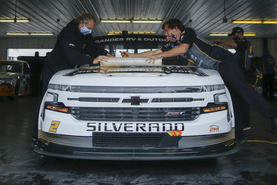 Crew members for Sheldon Creed wrap up the truck after the NASCAR Truck Series auto race scheduled for Saturday afternoon, June 27, 2020, was postponed to the next morning due to weather at Pocono Raceway, in Long Pond, Pa. (AP Photo/Matt Slocum)