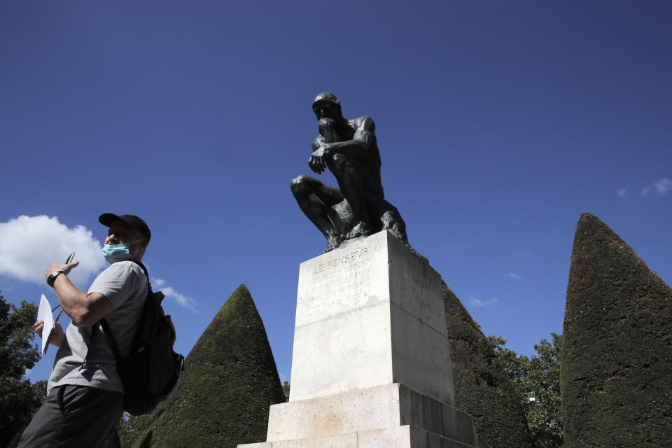 Un visitante pasa junto a "El pensador" de Auguste Rodin en París el martes 7 de julio de 2020. El Museo Rodin reabrió el martes tras haber pasado cuatro meses cerrado debido a la pandemia del coronavirus. (AP Foto/Christophe Ena)