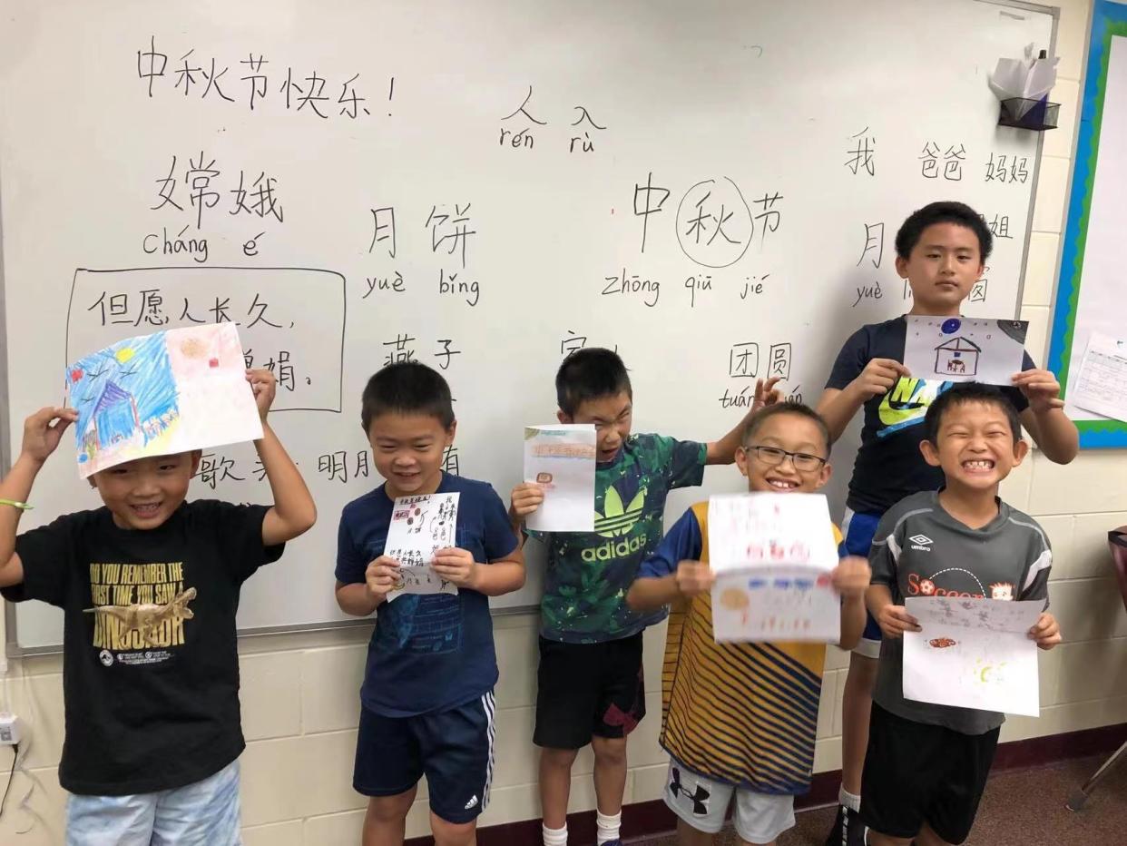 A group of students from the Huagen Chinese School show off their artwork.