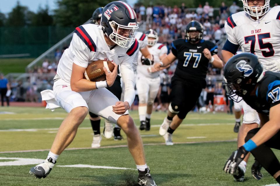 Central Bucks East quarterback Pat Keller prepares for contact with Central Bucks South defensive back Owen Wheeler.