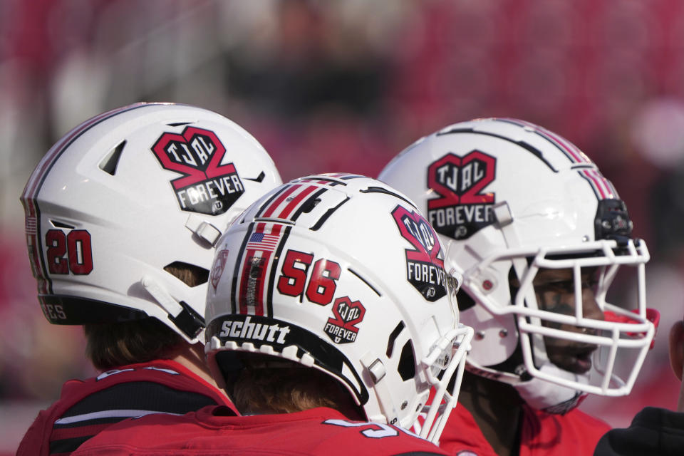 Utah football players wear a special helmet honoring slain Utah football players Ty Jordan and Aaron Lowe, before an NCAA college football game against Colorado, Friday, Nov. 26, 2021, in Salt Lake City, Utah. (AP Photo/George Frey)