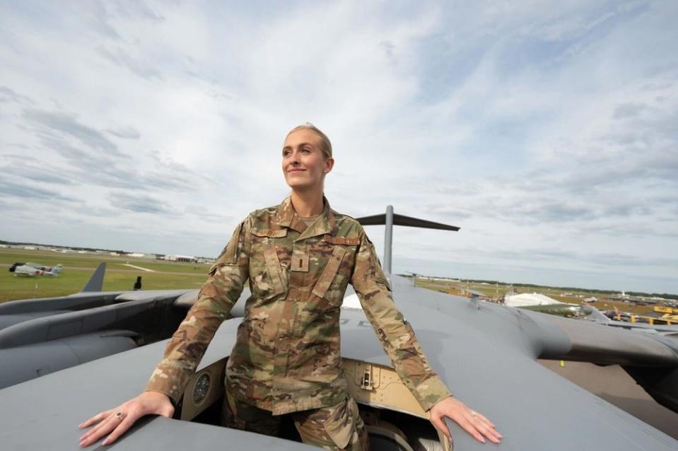Second Lieutenant Madison Marsh poses for a photo through the open hatch of a C-17 Globemaster.