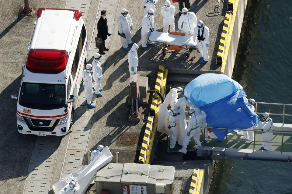 Pictures are officers escorting a person (under the blue sheet) who was on board cruise ship Diamond Princess and tested positive for coronavirus.