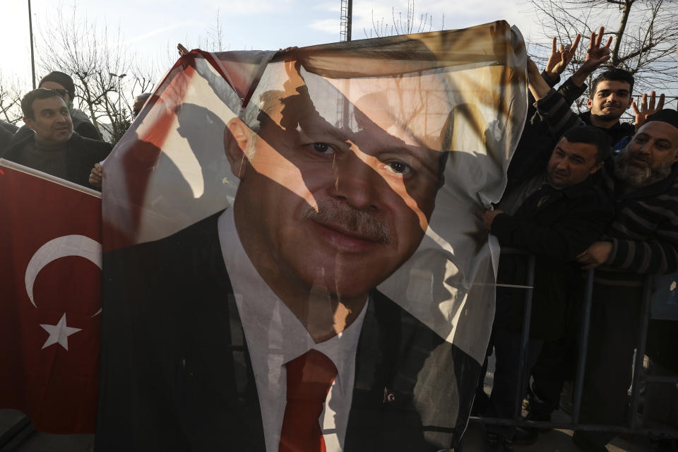 Supporters of Turkey's President Recep Tayyip Erdogan's ruling Justice and Development Party (AKP) hold a banner with his picture a day outside the party's headquarters after the local elections in Istanbul, Monday, April 1, 2019. Turkey's opposition dealt Erdogan a symbolic blow by gaining ground in key cities in the country's local elections. The opposition won the capital, Ankara, a ruling party stronghold for decades, and was leading a tight race for mayor in Istanbul, according to unofficial figures Monday. (AP Photo/Emrah Gurel)