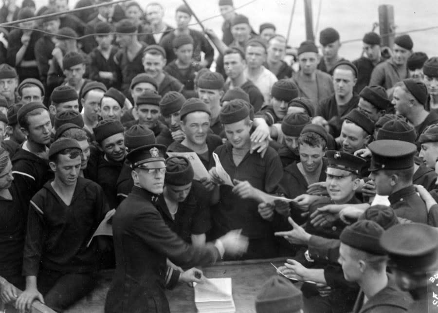 USS Pennsylvania (BB-38) Chaplain distributing the ship’s newspaper to sailors and Marines of her crew, circa 1918. Almost all the Sailors present are wearing knitted watch caps. (U.S. Naval History and Heritage Command Photograph)