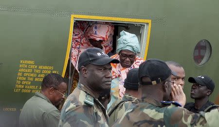 Cameroonian military personnel watch as freed hostages disembark from a military plane upon arriving at the Nsimalen International Airport in Yaounde November 26, 2014. REUTERS/Stringer