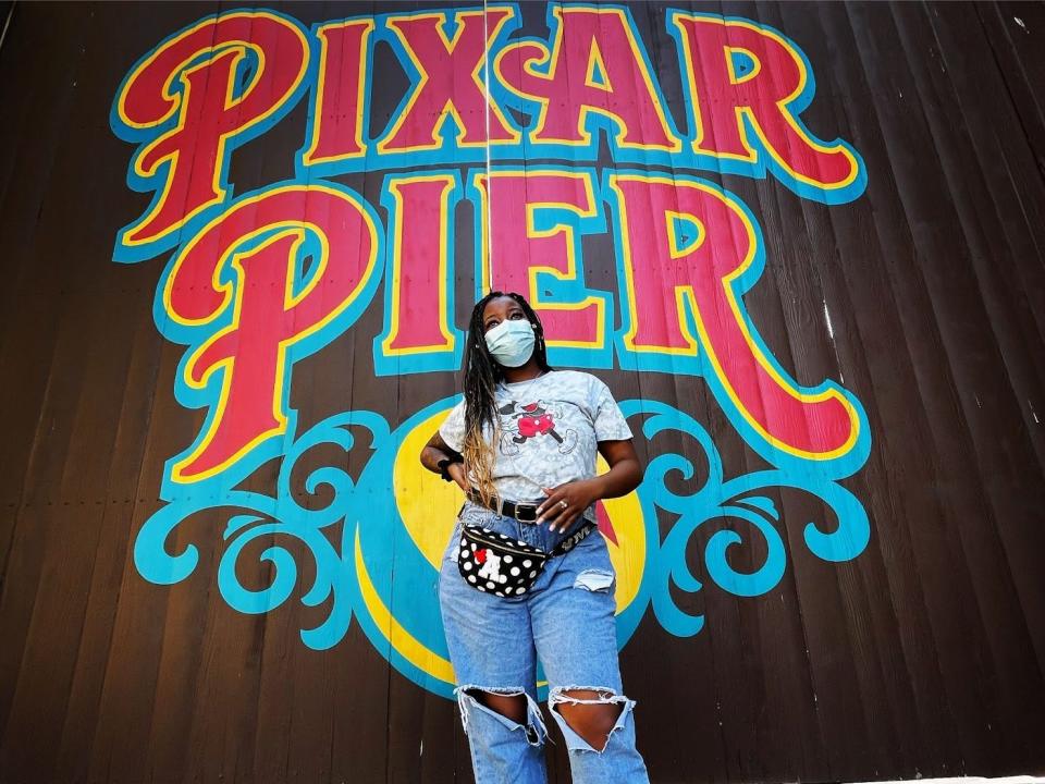 amber posing in front of pixar pier sign at disneyland