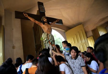 Filipino Catholic devotees touch the statue of crucified Jesus Christ after attending a mass at a National Shrine of Our Mother of Perpetual Help in Baclaran, Paranaque city, metro Manila, Philippines September 18, 2016. REUTERS/Romeo Ranoco