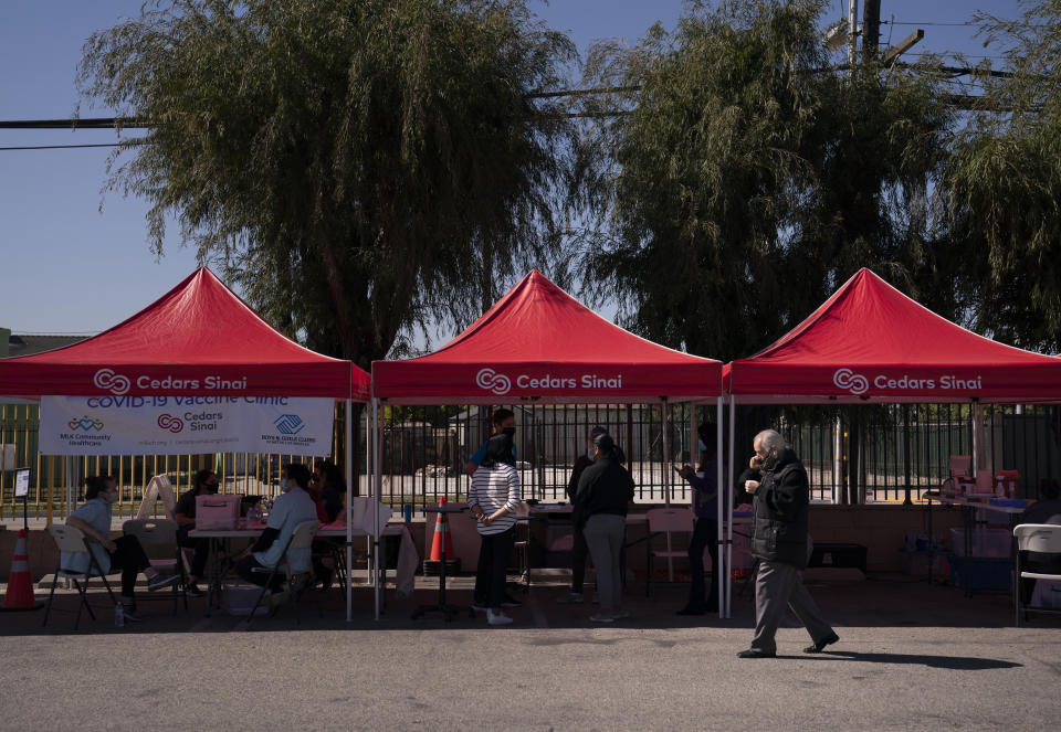 Manuel Martinez, 78, right, leaves after receiving the Johnson & Johnson's COVID-19 vaccine at a Cedars-Sinai sponsored pop-up vaccine clinic at the Watts-Willowbrook Boys & Girls Club in Los Angeles, Wednesday, April 28, 2021. California, swimming in vaccine, is in a far different place than it was just weeks ago when simply scoring an appointment was cause for celebration. Today, Los Angeles, San Diego and other populous counties are advertising that anyone can walk in for a shot and the state is texting reminders that plenty of appointments are available. (AP Photo/Jae C. Hong)