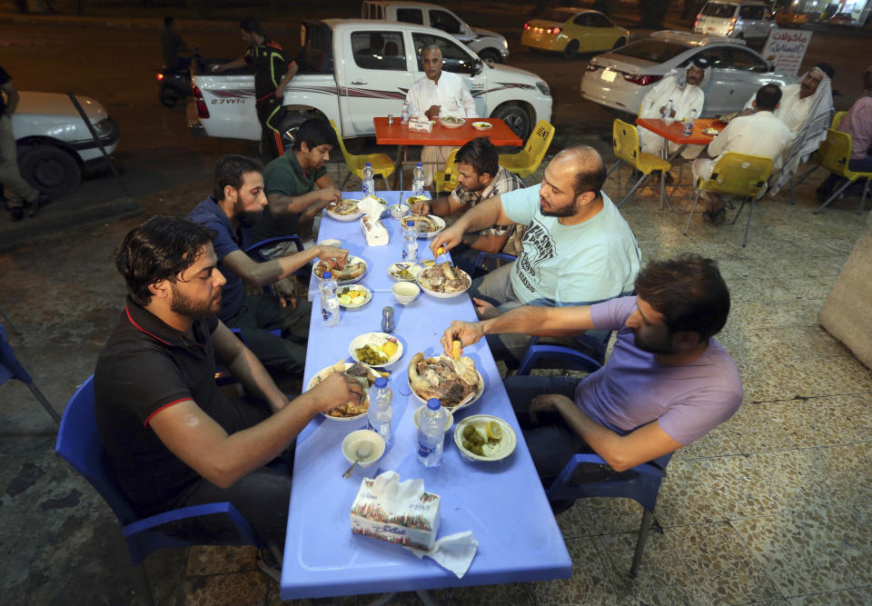 In this Sunday, Oct. 30, 2016 photo, customers eat pache at a restaurant in central Baghdad, Iraq. There are any number of delicious recipes that put the Iraqi city of Mosul on the culinary map long before it was devoured by the Islamic State group. And there is pache _ the head, intestines and other parts of animals, boiled in giant vats. (AP Photo/Hadi Mizban)
