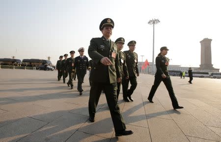 Military delegates from the Chinese People's Liberation Army (PLA) walk toward the Great Hall of the People for a meeting during the annual session of China's parliament, the National People's Congress (NPC), in Beijing, China March 4, 2017. REUTERS/Jason Lee