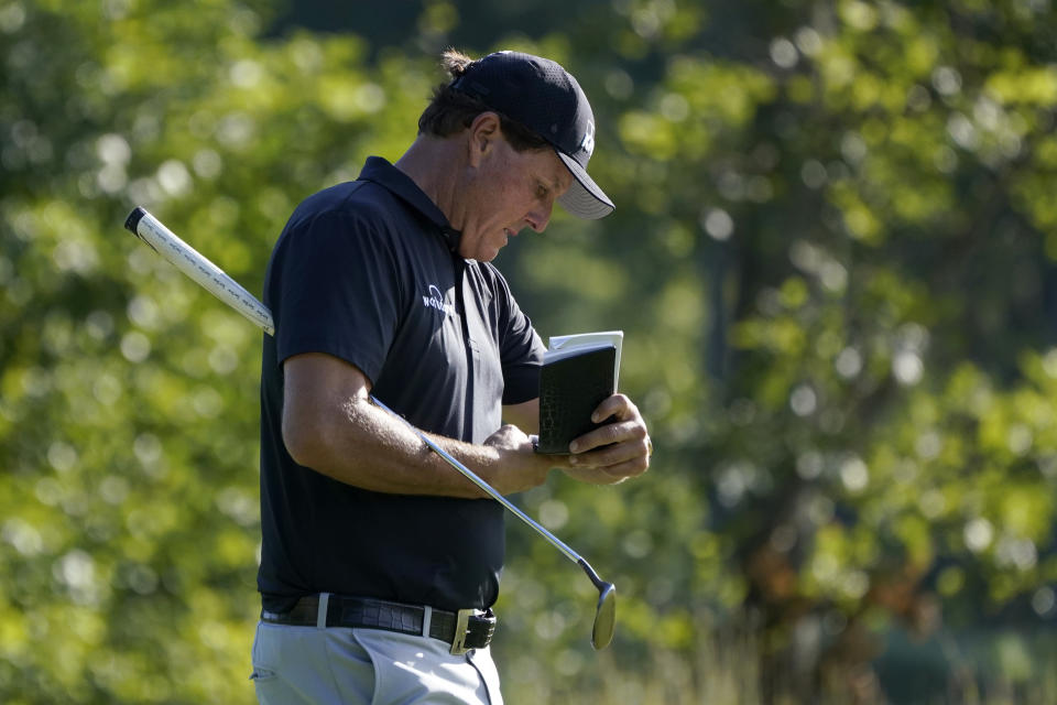 Phil Mickelson refers to his notes as he walks up onto the 14th green during the second round of the Northern Trust golf tournament at TPC Boston, Friday, Aug. 21, 2020, in Norton, Mass. (AP Photo/Charles Krupa)