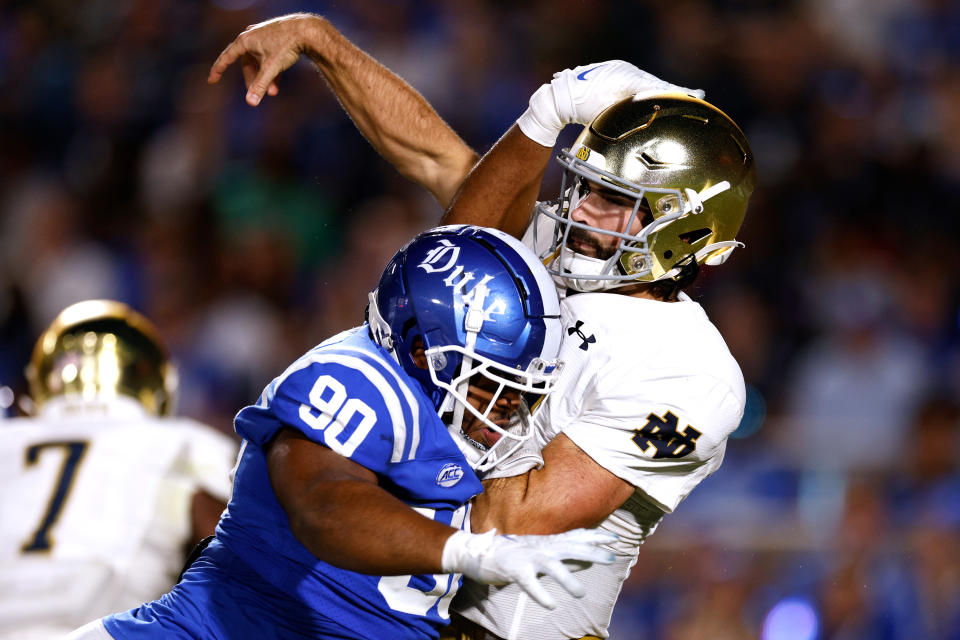 DURHAM, NORTH CAROLINA – SEPTEMBER 30: DeWayne Carter #90 of the Duke Blue Devils hits Sam Hartman #10 of the Notre Dame Fighting Irish after his pass during the first half at Wallace Wade Stadium on September 30, 2023 in Durham, North Carolina. (Photo by Lance King/Getty Images)